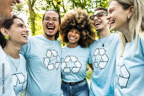 Fototapeta Multi ethnic group of volunteers cleaning up a forest together - Happy team of environmental activists smiling together outdoors - Environmental protection and non profits organization concept