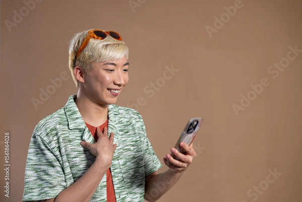Obraz Young Man Smiling at Phone in the Studio