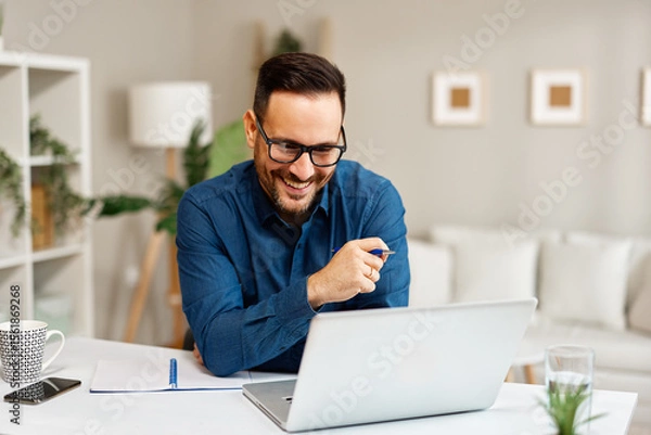 Obraz Happy entrepreneur working from home having a successful video call on laptop