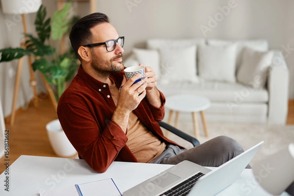 Obraz Freelancer enjoying a coffee break while working from home office