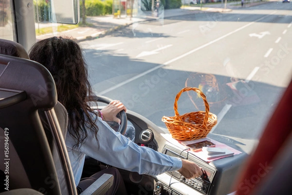Fototapeta Young Woman Bus Driver Navigating Open Streets.