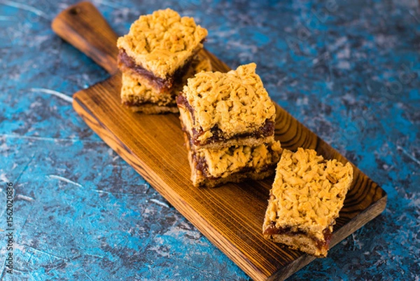 Obraz Delicious homemade pie with apple jam. Crispy pieces of grated pie with jam on a wooden board close-up, apple and cinnamon aroma