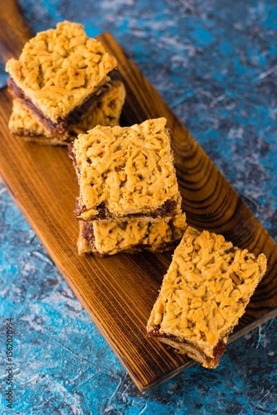 Obraz Delicious homemade pie with apple jam. Crispy pieces of grated pie with jam on a wooden board close-up, apple and cinnamon aroma