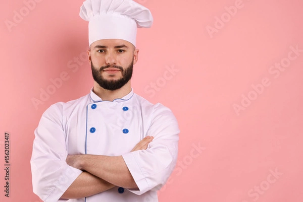 Obraz Portrait of confectioner in uniform with crossed arms on pink background