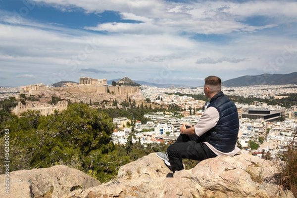 Obraz Young man admires the view of the Acropolis from Philopappos Hill