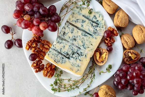 Obraz Gorgonzola cheese with walnuts, red grapes, and thyme.