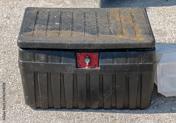 Obraz Dirty dusty closed locked black plastic toolbox outside