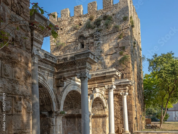 Fototapeta The Arch of ancient times. The famous gate, built in honor of the ancient Roman emperor. The Arc de Triomphe in the Kaleici area. Hadrian's Gate in Antalya. The arch is decorated with carved patterns.