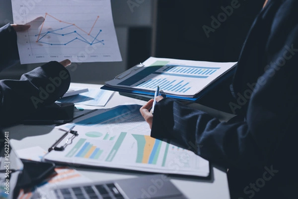 Obraz Group of business women working on a financial data expenses document.