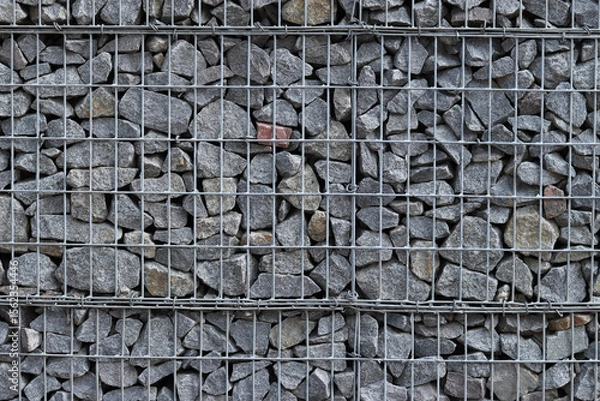 Fototapeta Rubble stone in galvanized mesh. Background. Gabion mattress made of woven mesh with stones for creating walls. Stones in mesh, creating decorative walls, strengthening