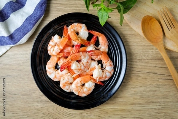 Obraz Boiled shrimp in black  ceramic plate on wooden background , top view food table 