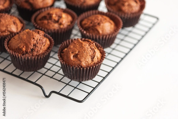 Obraz Freshly baked chocolate muffins on a cooling rack. Soft focus