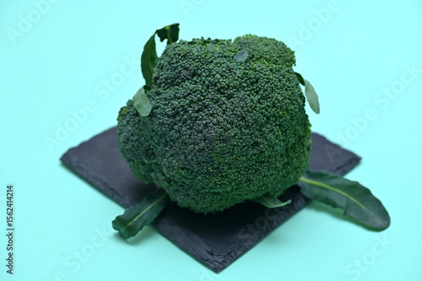 Fototapeta fresh head of broccoli cabbage on black board on green background