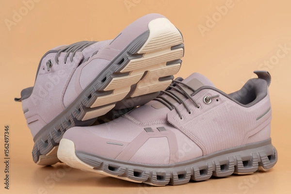 Obraz Stylish gray athletic shoes displayed on soft beige background portrait