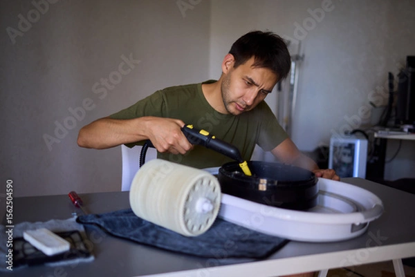 Fototapeta A man is utilizing a steam cleaner for effective home maintenance and cleanliness purposes
