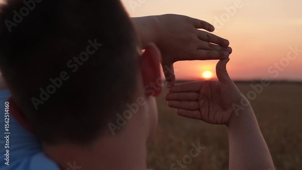 Obraz Child boy Seeing world as different Concept. Sees like in movies. Hands of teenager director cameraman making frame gesture at sunset. Business planning. Boy shows her fingers frame symbol in sun.