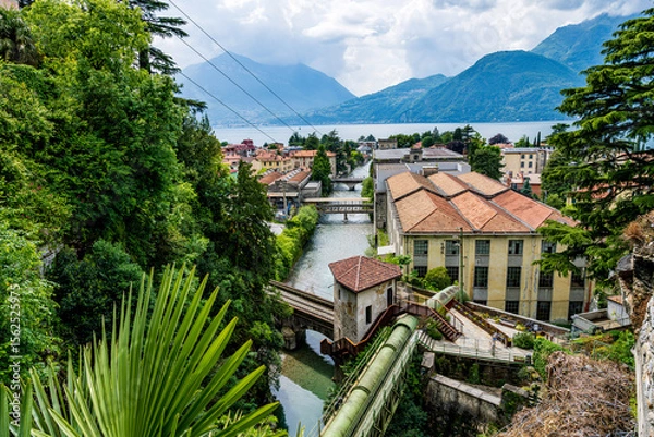 Obraz Bellano, Italy, located in the northern region of Lombardy, is shown in a wide view from Lake Como during a summer day.
