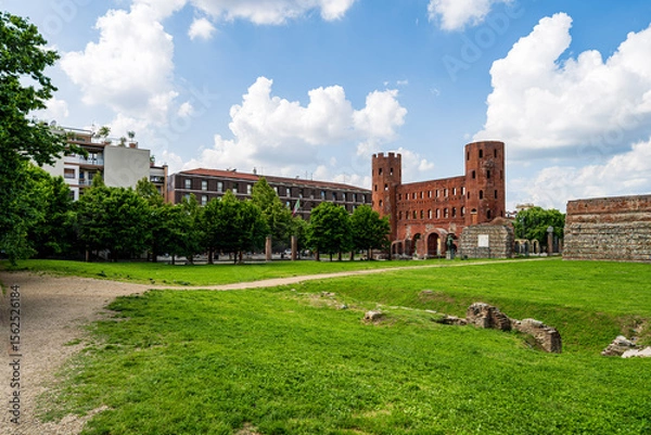 Obraz Historic Ruins Enthusiastically Surrounded by Lush Greenery and Modern Urban Architecture