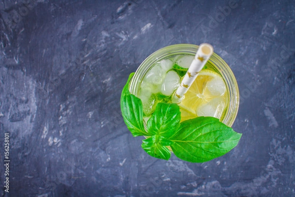 Fototapeta Top view. Sassy diet water. Cucumber, lemon, mint lemonade in glasses on grey background.
