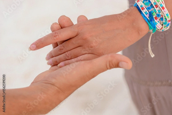 Fototapeta Man and woman, newlyweds holding hands with blurred background.