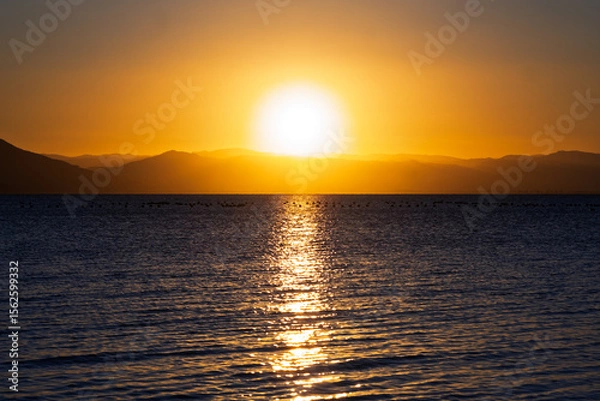 Fototapeta Serene Sunset Over Calm Waters: A Symphony of Colors Reflecting Tranquility