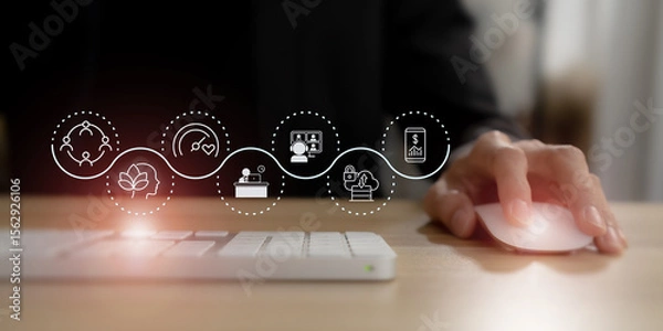 Obraz Digital wellbeing in workplace concept. Using a computer mouse, overlaid with icons representing digital wellbeing,  healthy work-life balance. Promoting a healthy relationship with technology.