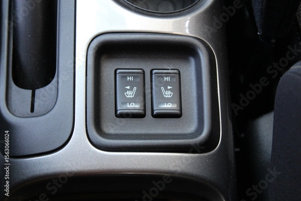 Fototapeta Front seat heating buttons on the cars central console. Seat heating buttons in the car interior. Double seat heating switch in a car.