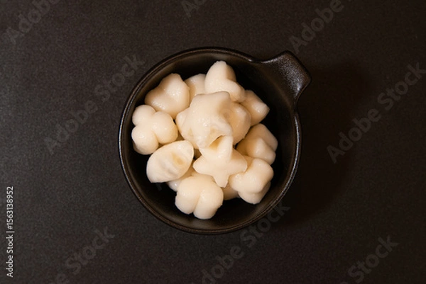 Fototapeta Close-up of Tteokbokki Rice Cakes in a Black Square Dish