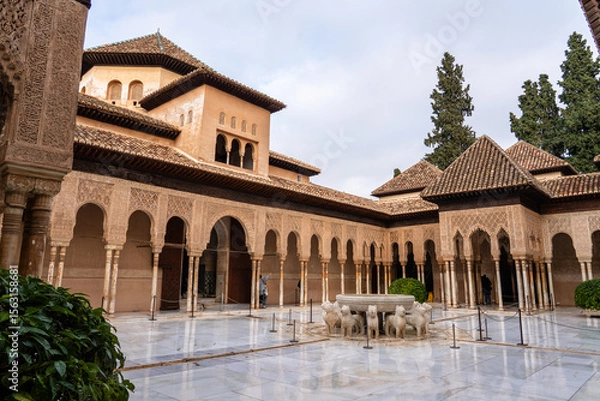 Fototapeta The interior courtyard of the Alhambra in Granada, Spain, highlighting its intricate Moorish architectural design. Tourists can be seen exploring this historic site.