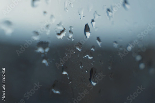 Fototapeta Raindrops on a foggy window create an abstract texture. The atmosphere of cloudy weather, nature, melancholy, comfort and tranquility