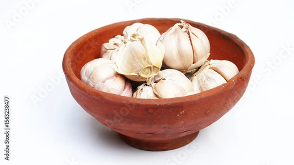 Obraz Close up of raw garlics on wooden bowl. top view. isolated white	
