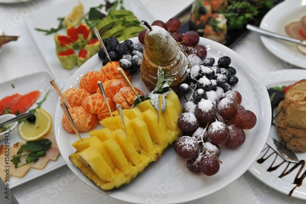 Fototapeta Bowl filled with different fruit on celebratory table.