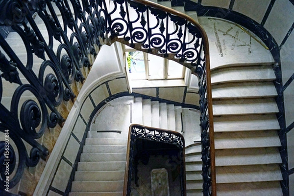 Fototapeta Architecture of historical houses in Belgrade, Serbia: staircase in the Museum of Applied Arts. View from the landing down to the entrance with a marble staircase and openwork wrought iron railings
