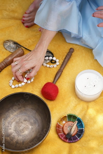 Fototapeta Calm hand arranges spiritual objects for meditation practice. Image is useful for illustrating mindfulness, wellness, or holistic lifestyle concepts.