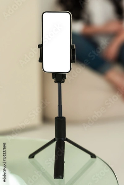 Fototapeta Blank smartphone tripod setup for content creation. Device is isolated for mockup or presentation use in digital projects.