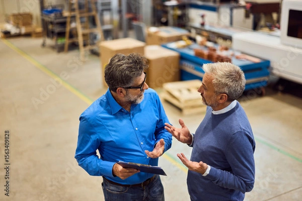 Fototapeta Two Colleagues Discussing Work in an Industrial Setting with a Collaborative Approach