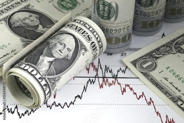 Fototapeta Diagram of stock market prices rates. One us dollar bills, rolled hundred us dollar bills. Ruler on the chart. Red and black lines on the graph.
