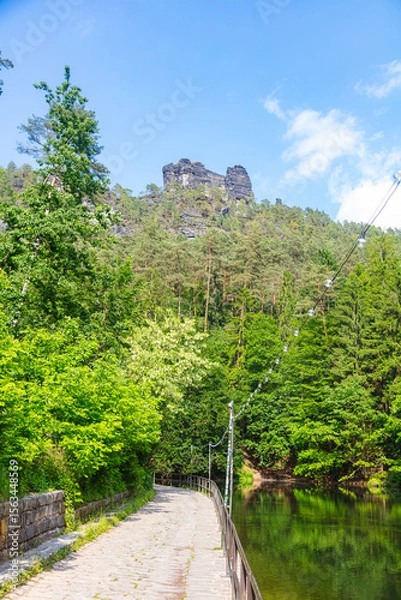 Obraz Scenic forest trail leading to the famous Bastei Bridge in Saxon Switzerland, Germany. Surrounded by lush greenery, sandstone cliffs and a small dam, this popular route offers pure hiking charm