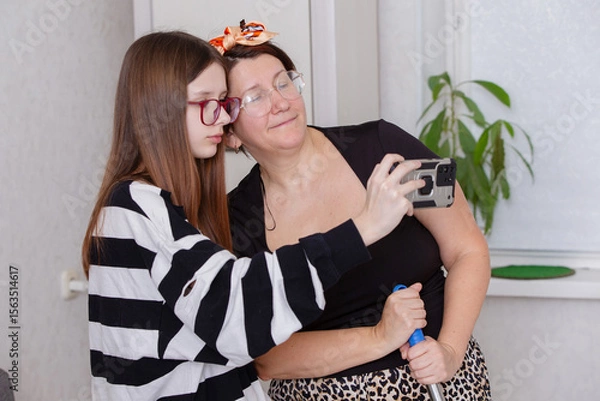 Obraz Family members enjoying a moment together while taking a selfie in a cozy indoor setting during daytime