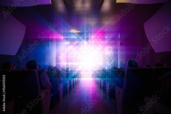 Obraz Vibrant lights illuminate audience enjoying performance at a theater in the evening