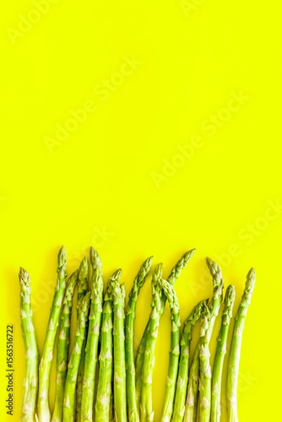 Obraz Asparagus steams frame on yellow background top-down copy space