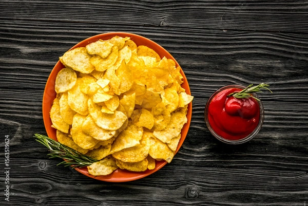 Obraz Potato chips served wiith ketchup on wooden background top view