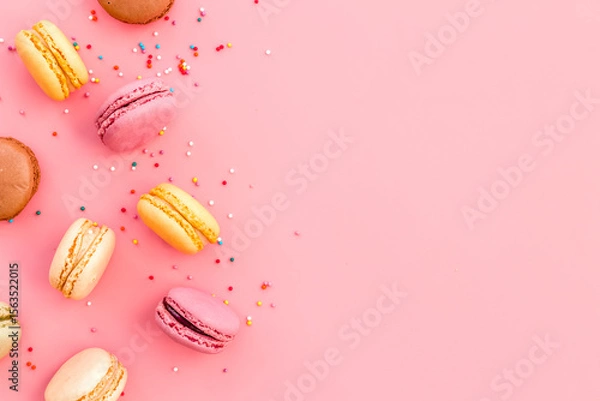 Obraz Brignt macarons for sweet break on pink background top view mock up