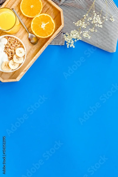 Obraz Bright breakfast with granola and orange juice on blue background top view mockup
