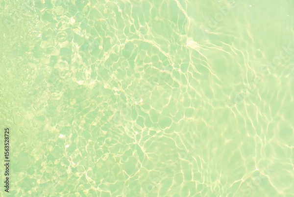 Fototapeta Blue water with ripples on the surface. Defocus blurred transparent blue colored clear calm water surface texture with splashes and bubbles. Water waves with shining pattern texture background.