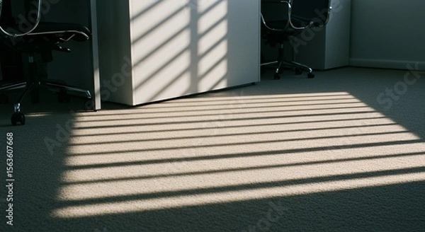 Obraz Sunlight streams through blinds, casting striped shadows across a carpeted office floor, illuminating empty chairs.