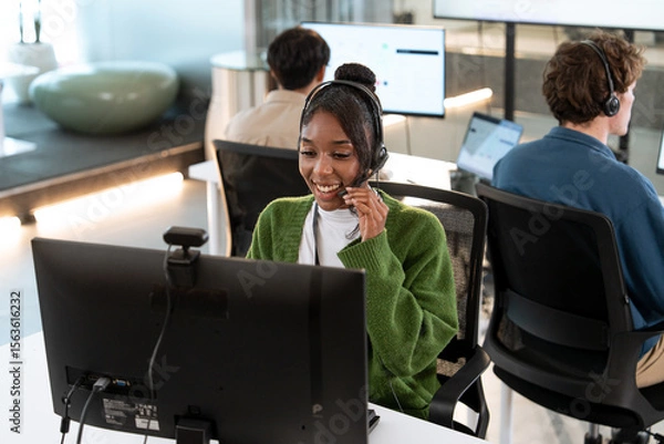 Fototapeta Smiling African American woman working customer support operator with headset. Female Call center agent, consulting and telemarketing concept, Customer service representative. online consultant.