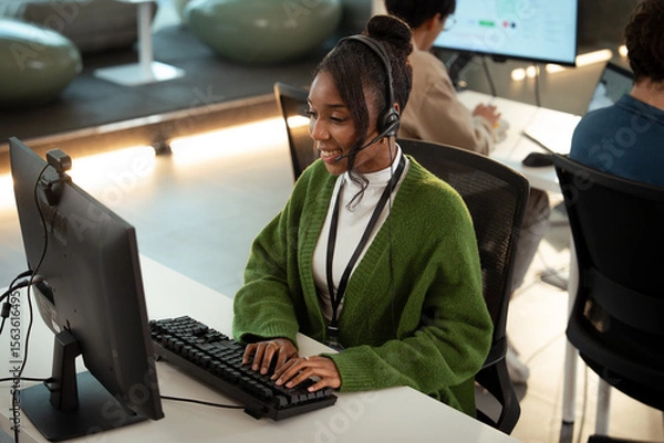 Fototapeta Smiling African American woman working customer support operator with headset. Female Call center agent, consulting and telemarketing concept, Customer service representative. online consultant.