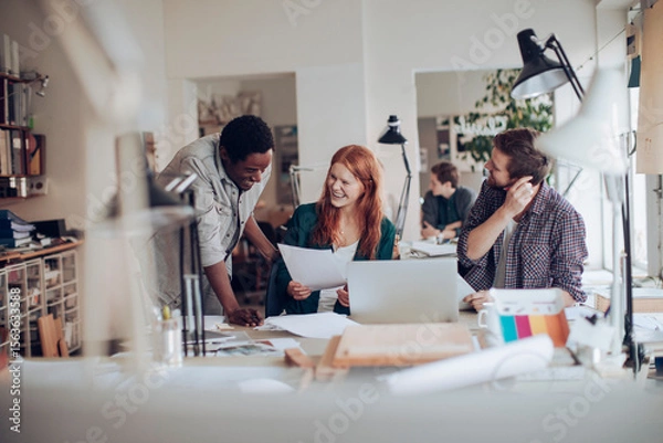Fototapeta Creative design team collaborating on architectural project in modern office