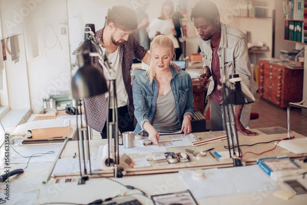 Fototapeta Creative design team collaborating on architectural project in modern office